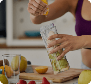 woman puts chopped fruits in a blender